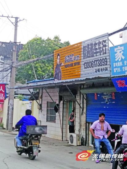 裕旺路上一家棋牌室门前挂着超威电池的门头