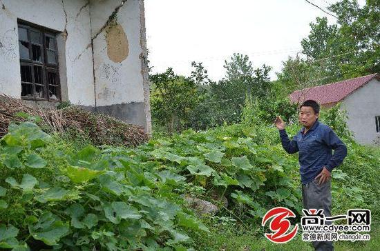 孙爸爸在自家破旧的房子前显得很无奈。 尚一网记者 胡稳 摄
