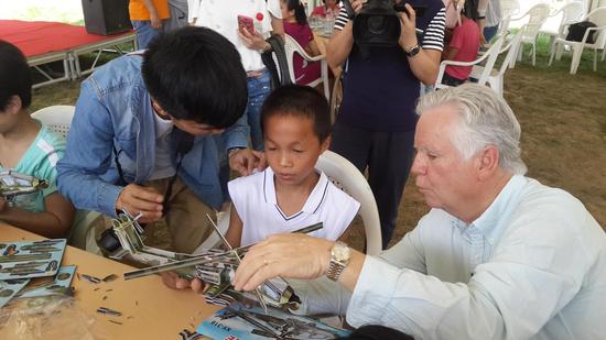 美國(guó)空中海報(bào)飛行表演隊(duì)的隊(duì)長(zhǎng)韋恩為孩子們講解飛機(jī)模型的制作