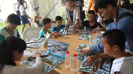 福利院的孩子們?cè)趷?ài)心人士幫助下做飛機(jī)模型