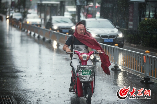 7月14日，入伏第二天，济南市泺源大街，突如其来的大雨让市民猝不及防。大众网记者王长坤 摄