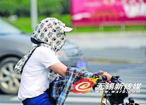 昨天,一名出行市民“全副武装”抵御高温日晒。(还月亮 摄)