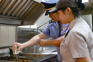检查人员对示范早餐店炸锅里的用油情况进行检测 记者 郑晓 摄