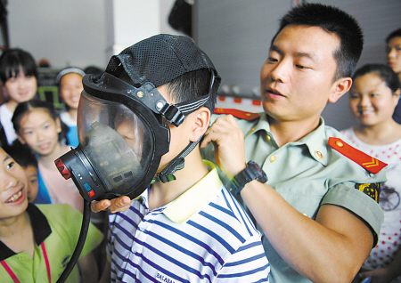 学生正体验高温下当一名消防战士的辛苦。