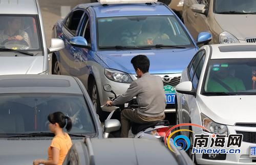 海垦天桥路段，电动车在车流中逆行。南国都市报记者刘孙谋摄