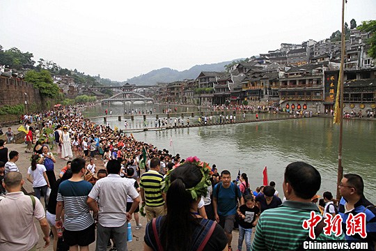 7月15日，湖南凤凰古城迎来暑期旅游热，众多游客扎堆古城内的大街小巷。麻正规 摄