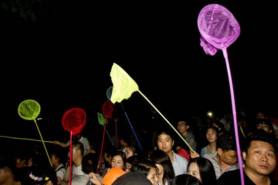 游客高舉事先準備好的專用工具張網以待