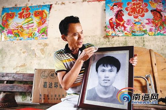 7月14日,符传道的父亲在擦拭儿子的遗像。本报记者张茂摄