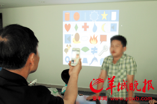 接受培训的孩子正尝试记住身后屏幕上的图案