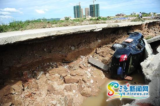 7月21日，水中桥桥面塌陷“吞噬”一辆汽车。(三亚新闻网记者沙晓峰摄)