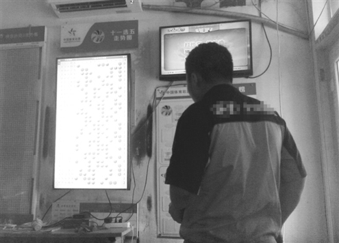 省城一彩民盯著彩票走勢圖，意圖從中尋出規律