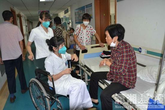 7月20日，湖南省胸科医院内二科主治医生赵富明坐着轮椅在查房。图/潇湘晨报通讯员 杨艳 胡美娥