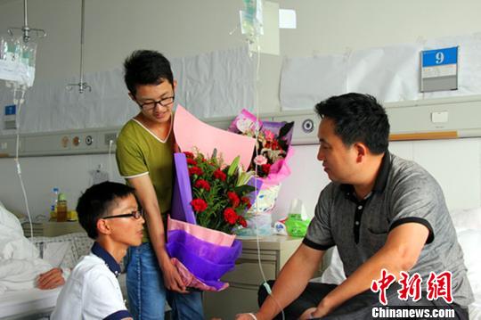 20日，太阳河中学2名刚毕业的学生到医院接谷成林出院 姚尧 摄