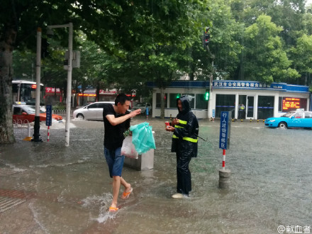 雨中暖流:就在刚才，洪山路东一路口，一位水务工作人员守在打开的下水道口。