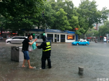 雨中暖流:就在刚才，洪山路东一路口，一位水务工作人员守在打开的下水道口。