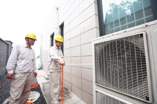 運維人員對空調外機散熱片進行清洗