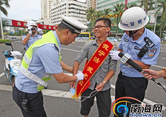 电动车主违规被抓，戴着绶带协助警方抓违规电动车辆。南国都市报记者汪承贤摄