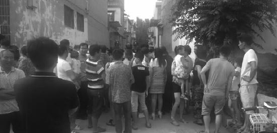 被封锁的案发街道外,聚集了大批关心案件进展的群众