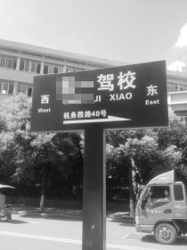 石峰区清石广场一块路牌上写着“某某驾校”的名字。《长株潭报》实习记者 李圣鹏摄