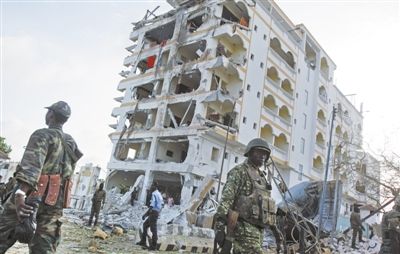 昨日，在索马里首都摩加迪沙，士兵经过汽车炸弹袭击现场。图/新华社