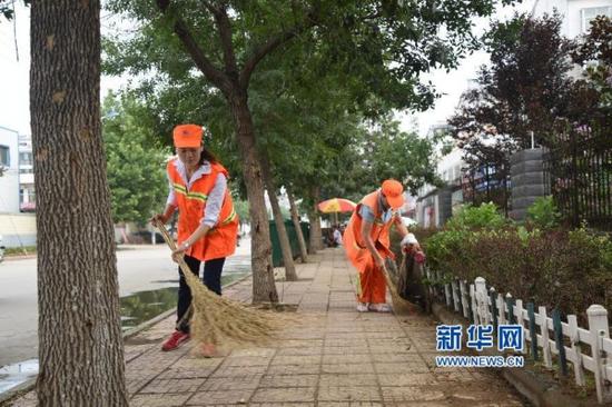 大学生陪养母扫马路