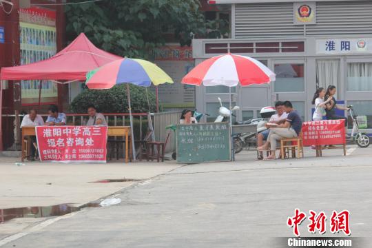 圖為淮陽中學大門口，復讀班招生的攤位一字擺開。 王登峰 攝