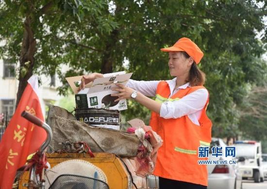 7月28日，大学生陈蒙恩在养母负责清扫的路段上捡拾垃圾。