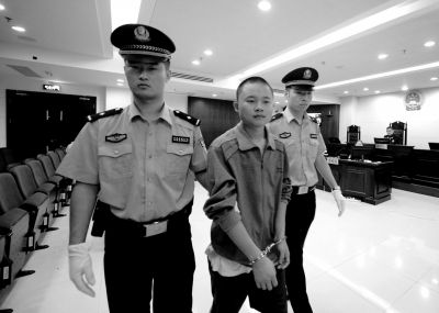 汪某被法警带出法庭。 京华时报记者 欧阳晓菲 摄