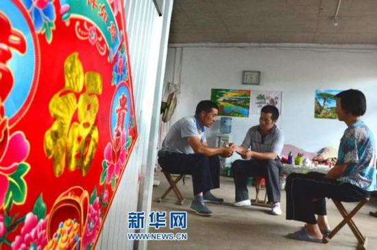 7月27日，“煎饼哥”江照云（中）为当地一户困难家庭送去爱心捐款。(赵东山 摄)