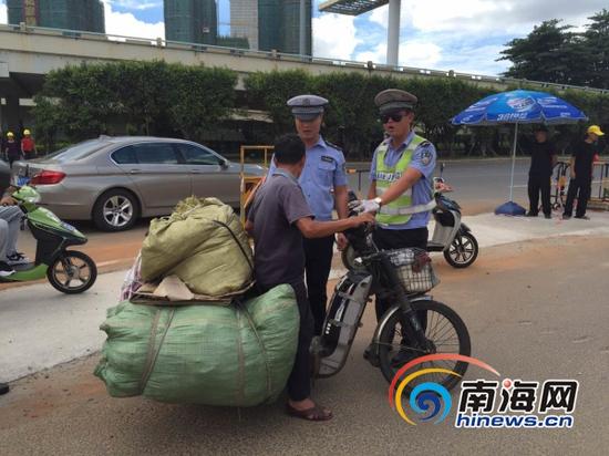 7月30日上午，民警在海口南大桥下南沙路口查处超载电动车(南海网记者组摄)