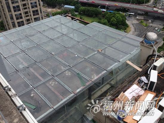 图为从天台俯视1706单元房搭建玻璃房,可以看见内部摆设餐桌,桌上还有餐具