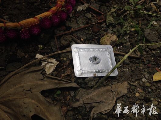 地上有一个土坑,还有一颗药品的外包装