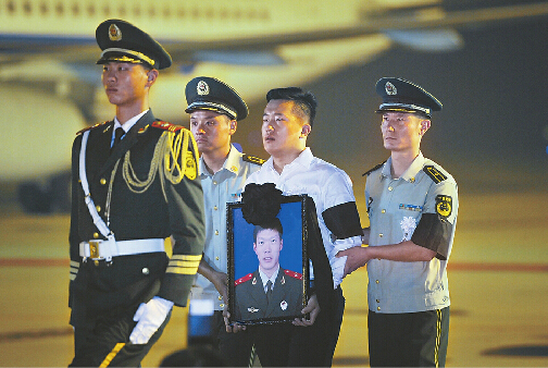 張楠堂弟手捧英雄遺像