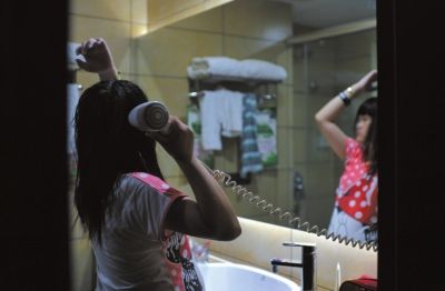深圳一家宾馆内，很久都没能洗澡的思思终于洗了个热水澡，放松地为自己吹干头发。