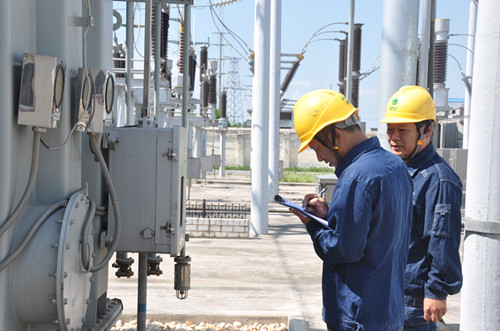 員工在對110千伏泌陽變電站主變檢測油面溫度計