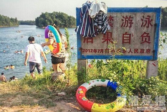 8月2日，宁乡县白马桥水库，河堤上竖着禁止游泳的警告牌，却依然有不少市民下水游泳。图/潇湘晨报记者张迪晨报记者张迪