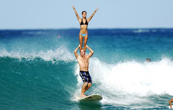 近日，夏威夷威基基海滩上演了一场别开生面的双人冲浪比赛秀。