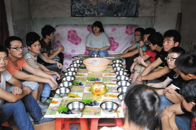 7月30日中午，静海县一个传销窝点，传销人员围坐在餐桌前等待开饭。午饭是白水煮面条。 