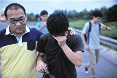 7月30日傍晚，被骗进传销窝点整整七天的广西籍小伙李楠（右）终于被解救，看到同学后低头大哭。