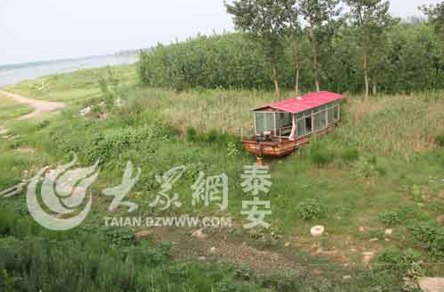 東平湖戴村壩旁的船只飯店以前浮在水面,如今已擱淺。(趙偉 攝)