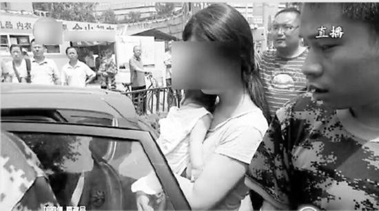 婴儿被困车中，消防队员紧急施救。(视频截图)