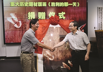 新华报业传媒集团周跃敏社长（右）接受陈超的捐赠。