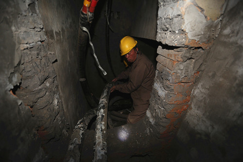 潮濕泥濘的電纜通道內，師傅們齊心協力將電纜移動至安裝位置