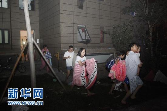 8月12日,天津滨海新区开发区发生剧烈爆炸后,市民涌向街边。当晚11时30分左右,天津滨海新区开发区发生剧烈爆炸,爆炸火光冲天,引发的烟尘高达数十米。 新华社发(总汇摄)