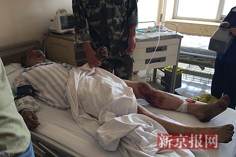 周倜在病床上接受治疗,班长李建争紧握周倜双手。新京报记者 程媛媛 摄