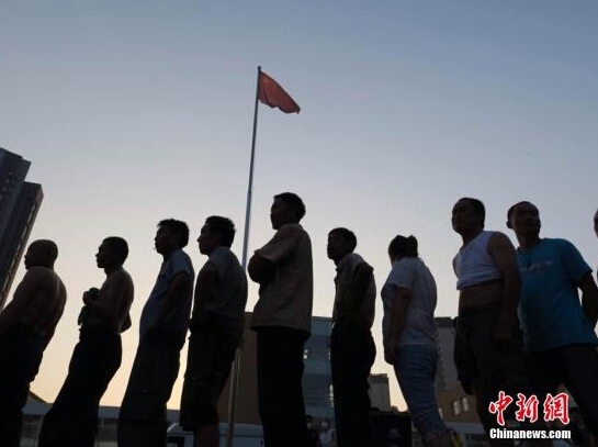 8月13日,泰达二中安置点市民排队领餐。 石岩 摄