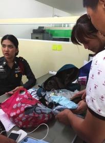 8月13日下午,芭提雅警察局,办案警官将张春蓉遗物交给其父母。 图/记者王欢