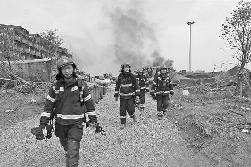 14日，天津消防人员在天津港瑞海公司危险品仓库特别重大火灾爆炸事故现场进行勘查，准备对一处火点进行处置。 新华社发王吉良张奇微博供图