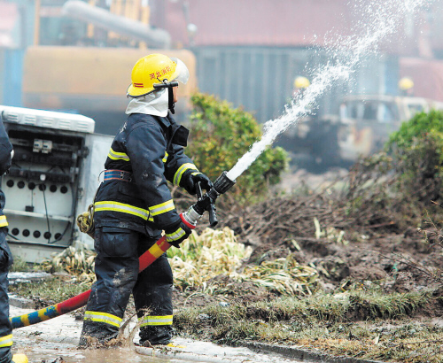 8月14日，消防人员在天津港瑞海公司危险品仓库特别重大火灾爆炸事故现场扑灭一个集装箱内的明火。新华社发