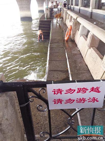 ▲ 沙面一中年男子在禁止游泳的地方戏水,身边是一个用于救援的救生圈。